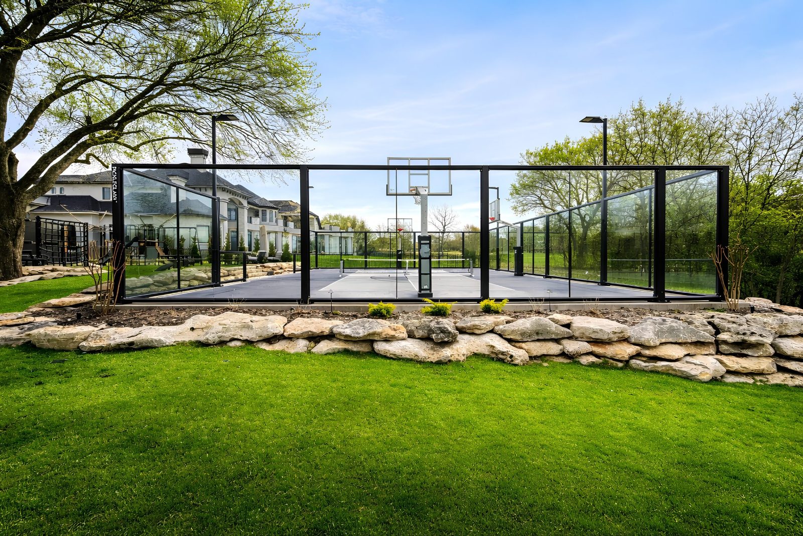 A complete premium court amenity showing surface, acoustic-rated enclosure, and integrated lighting scoped as one system
